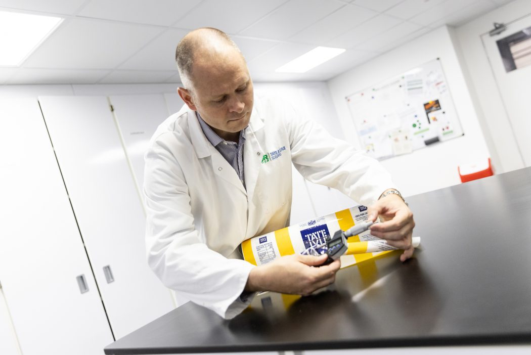 Man in laboratory coat measures bag of sugar