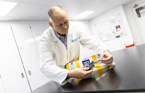 Man in laboratory coat measures bag of sugar