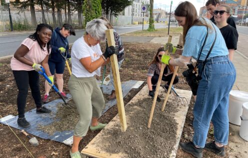 Team of volunteer bash mud and break soil in to small pieces