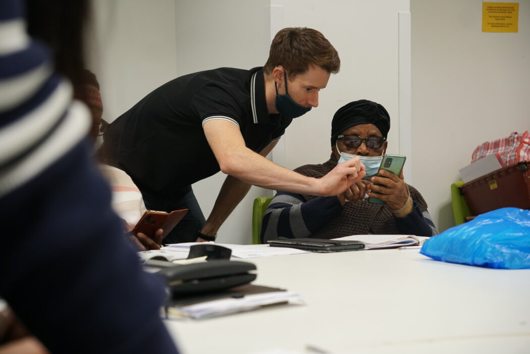 Volunteers helps older person with their smartphone