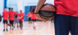 Man holds basketball with the word NASSA written on it 