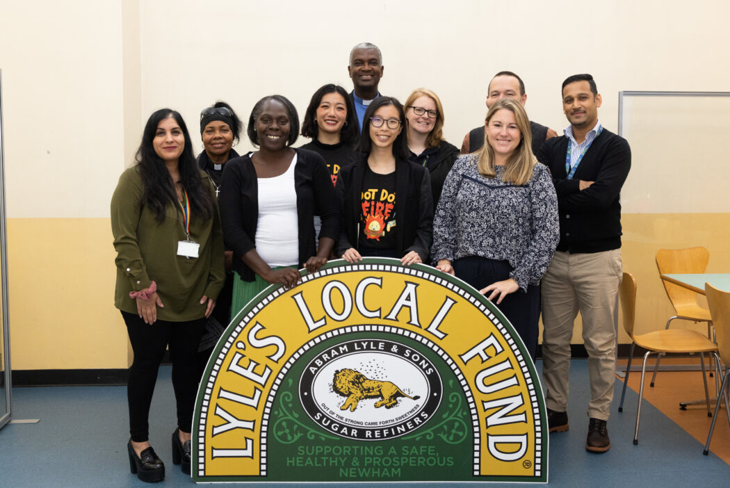 Group of people stand with a sign saying Lyle's Local Fund
