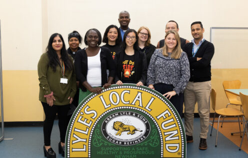 Group of people stand with a sign saying Lyle's Local Fund