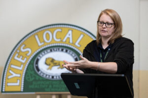 A lady standing at a lectern delivers a speech