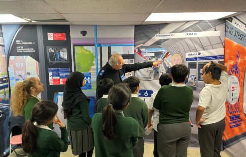 Police office points to picture on wall in front of school children