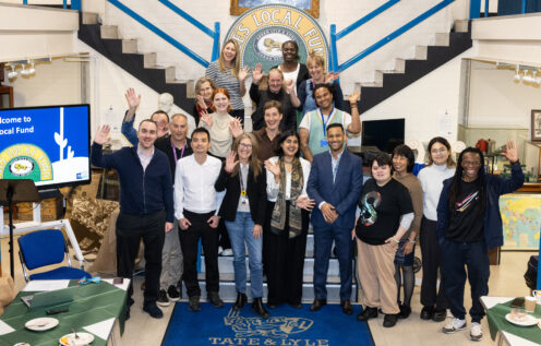 Group of people stand on stairs waving at camera