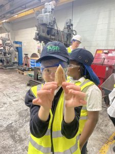 A student in hi-vis holds a congealed piece of sugar