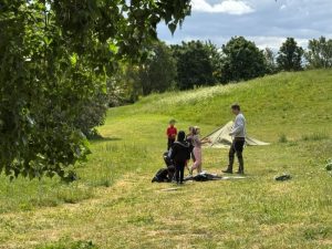 Children led by Forest School leader setting up tents