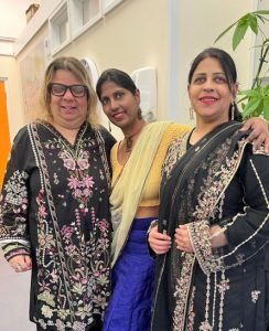 Sameena Karim, Head of VIPON, stands with two attendees at a community event, posing for a photograph in a community centre.